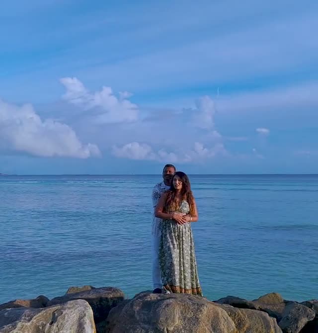 A couple embracing on the rocks by the sea